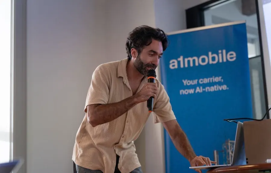 Presenting on the mic beside the a1mobile banner